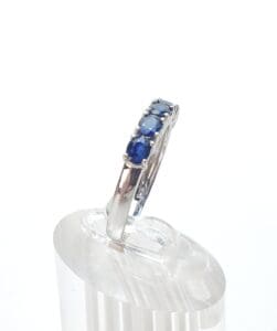 Silver ring with blue gemstones on display.