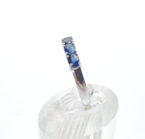 Silver ring with blue gemstones on display.
