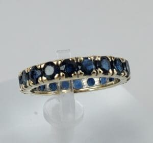 Gold ring with blue gemstones displayed.