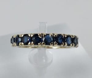 Gold ring with embedded dark blue stones.
