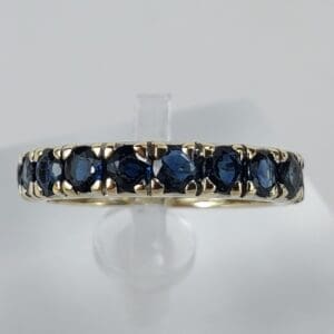 Gold ring with embedded dark blue stones.