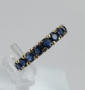 Gold ring with blue gemstones on display.