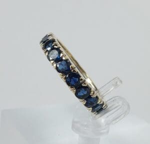 Gold ring with blue gemstones on display.
