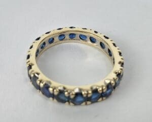 Gold ring with blue gemstones on display.