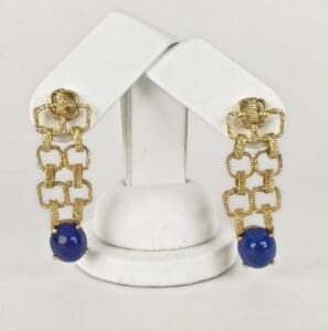 Gold chain earrings with blue beads displayed.