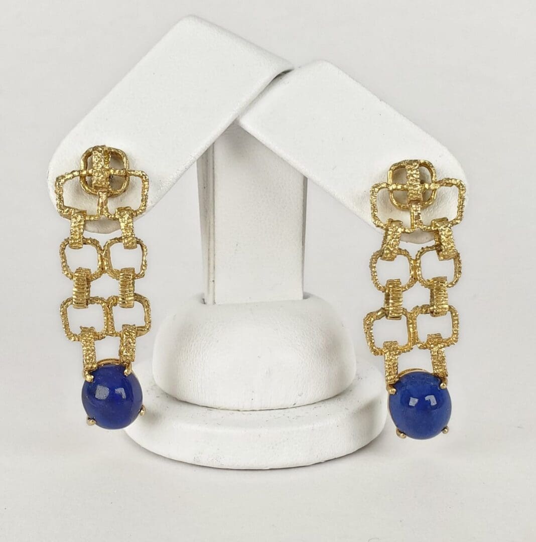 Gold chain earrings with blue beads displayed.