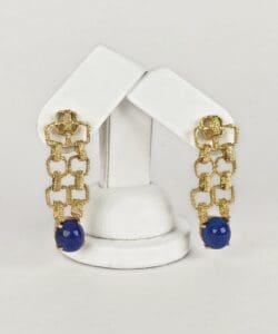 Gold earrings with blue beads displayed elegantly.