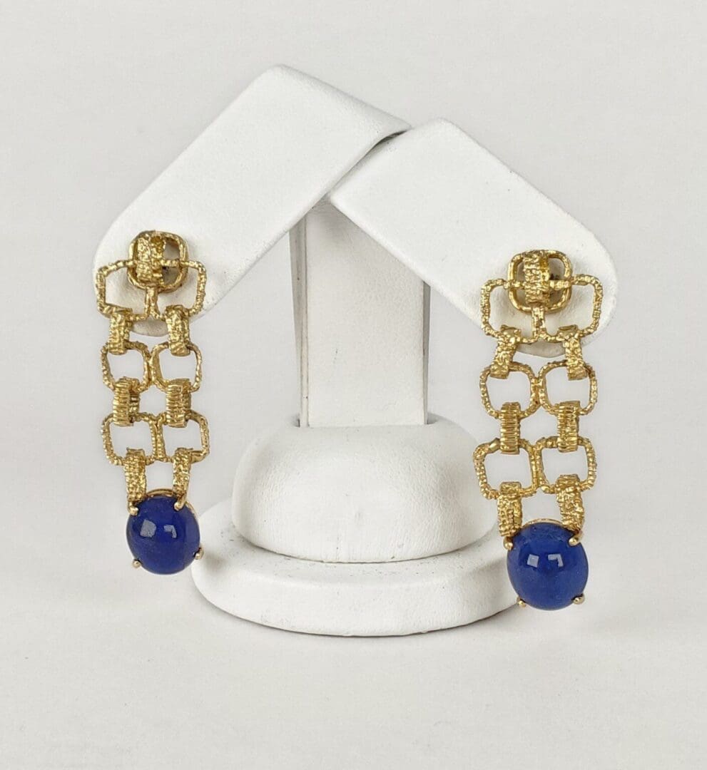 Gold chain earrings with blue beads displayed.
