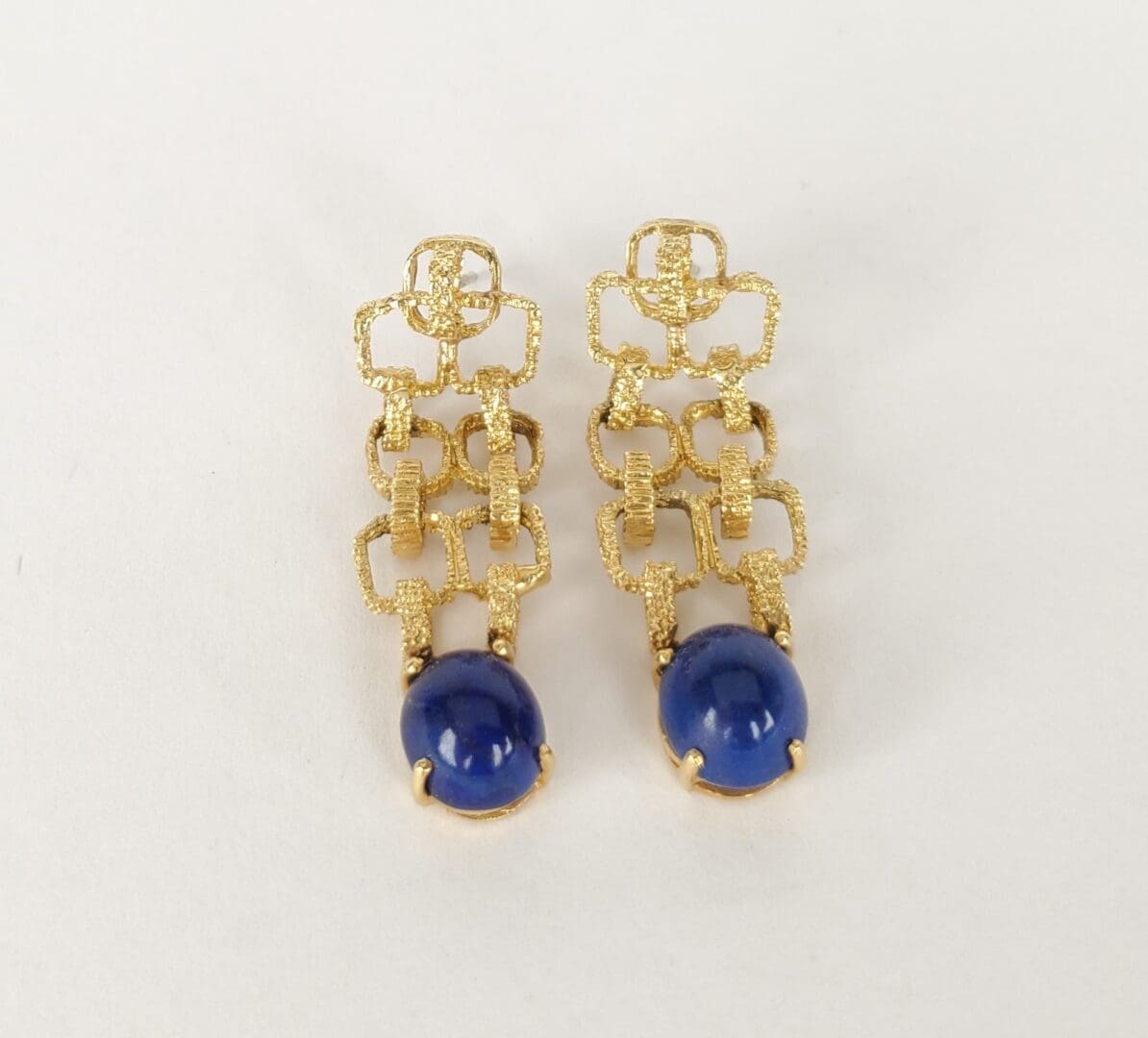 Gold earrings with blue stone accents.