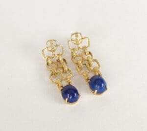 Gold earrings with blue gemstone drops.