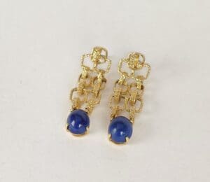Gold earrings with blue gemstone drops.