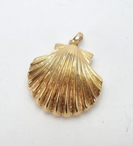 Gold shell-shaped pendant on white background.