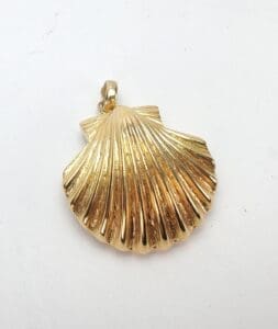 Gold seashell-shaped pendant on white background.