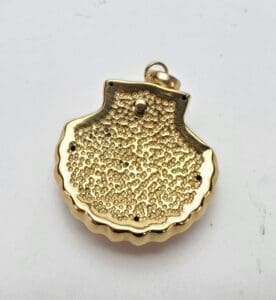 Gold shell-shaped pendant on white background.