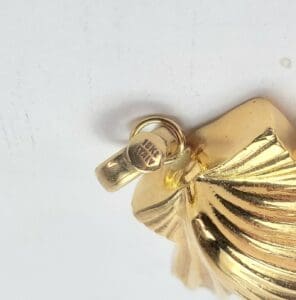 Gold pendant with textured design.