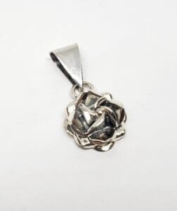 Silver rose pendant on white background.
