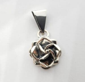 Silver rose pendant on white background.