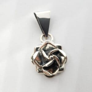 Silver rose pendant on white background.
