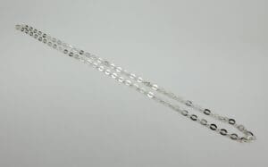 Silver chain necklace on white background.