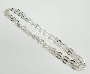 Silver chain necklace on white background.