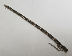 Silver bracelet with intricate black detailing.