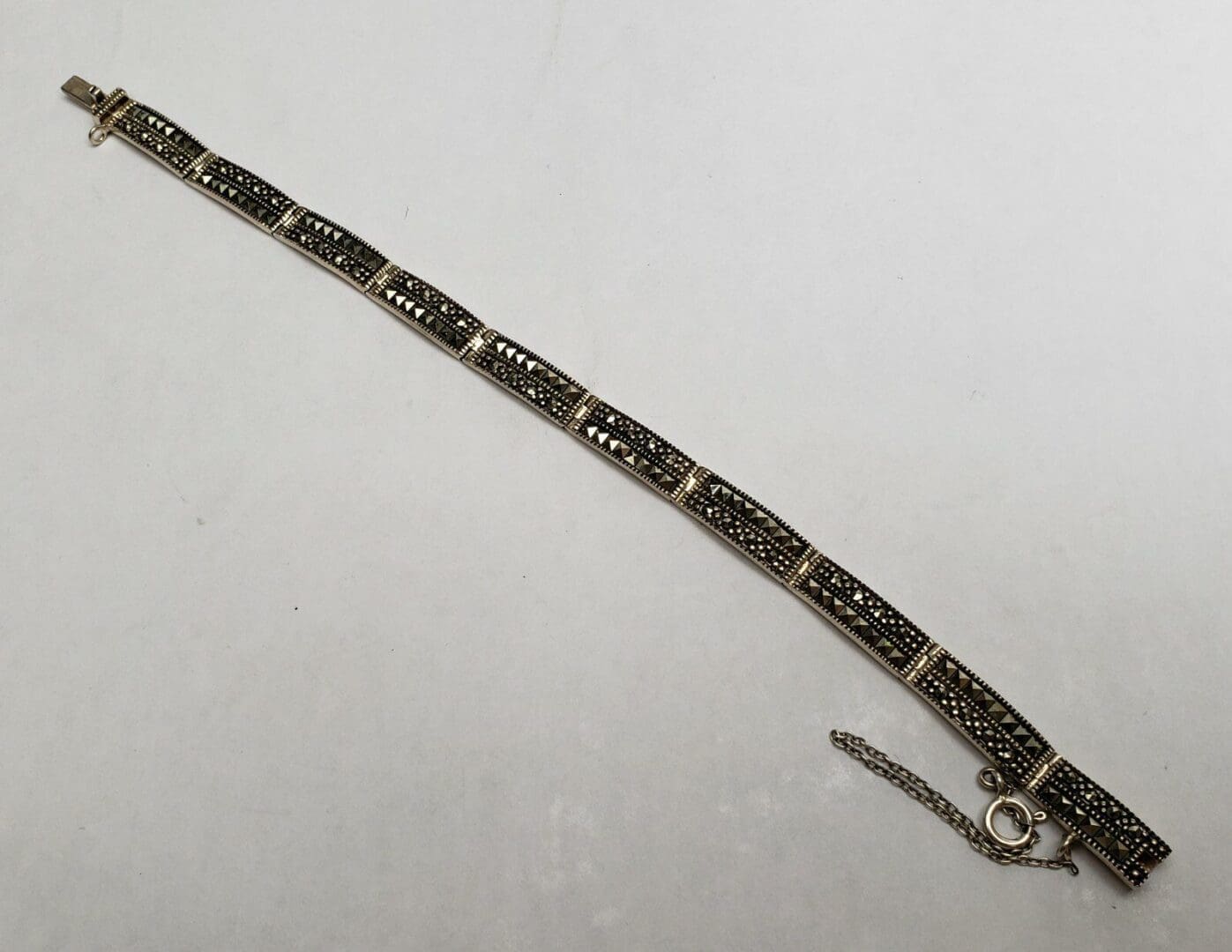Silver bracelet with intricate black detailing.