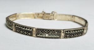 Silver bracelet with intricate geometric design.