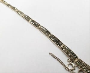 Silver bracelet with intricate design and clasp.