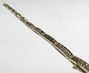 Intricate silver bracelet on white background.