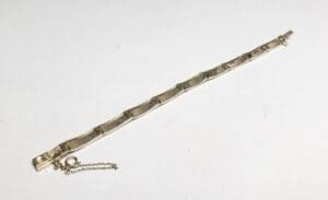 Gold bracelet with chain on white background.