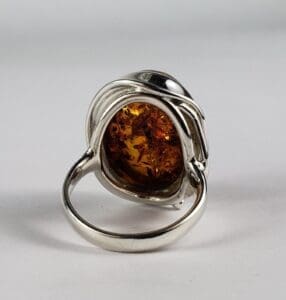 Silver ring with amber gemstone centerpiece.