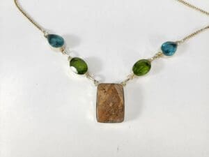 Gemstone necklace with pendant and colored stones.