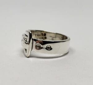 Silver ring with buckle design detail.