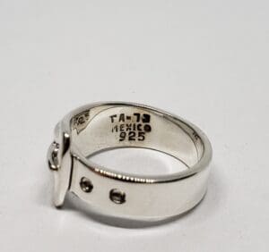 Silver ring with engraved markings inside band.