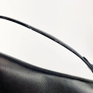 Black leather handbag with a strap.