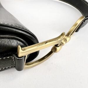 Black leather bag with a gold buckle.