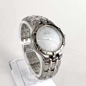 Silver stainless steel wristwatch on display stand.