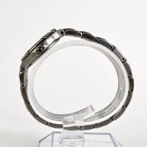 Silver wristwatch on a transparent stand.