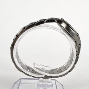 Silver wristwatch displayed on a clear stand.