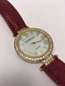 Gold watch with red leather strap.