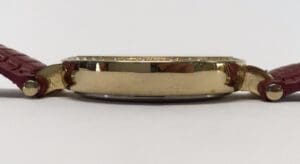 Gold watch with red leather straps.