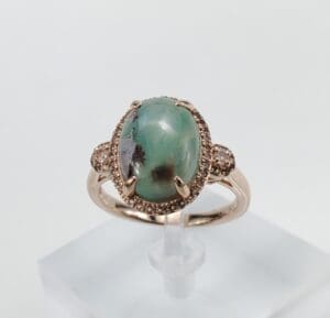 Gold ring with large green gemstone.