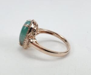 Rose gold ring with green gemstone.