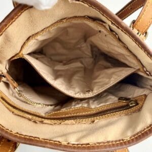 Inside view of an open leather handbag.