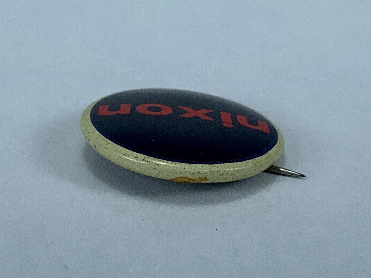 Round pin with red text, "Nixon.