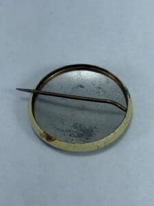 Backside of a vintage metal pin badge.