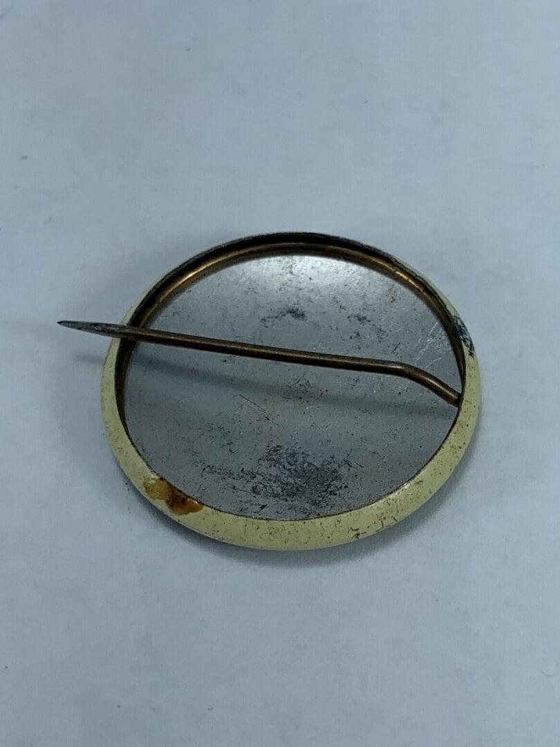 Backside of a vintage metal pin badge.
