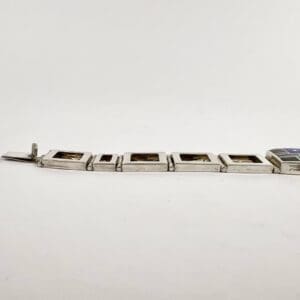 Silver bracelet with rectangular links and clasp.