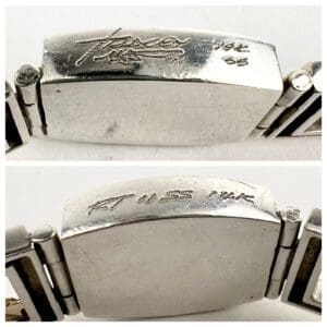 Silver bracelet with engraved markings.