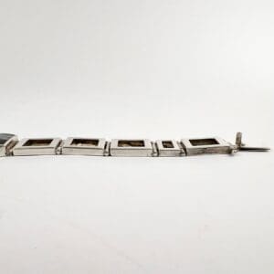 Silver bracelet with square links displayed.
